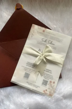 Maroon color envelope with floral card, buttersheet, bow, wax seal and flower.