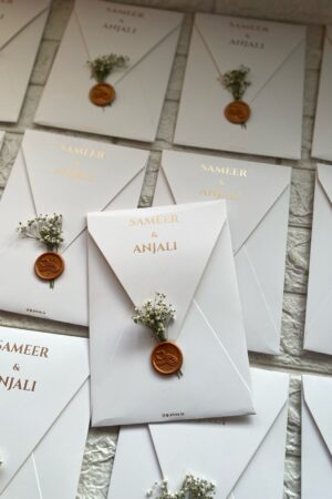 off white envelope card with wax seal and fresh flower