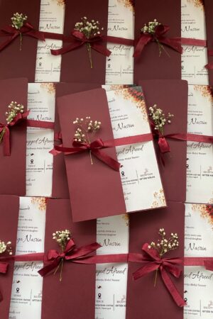 Floral card with maroon color cover, bow and flower.